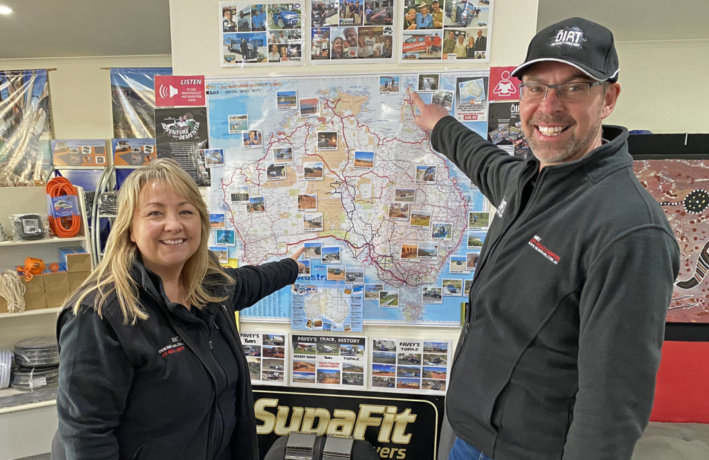 Mike and Anita Pavey standing beside their Australian travel map at The Dirt Off Road Campers in Mount Barker, SA.