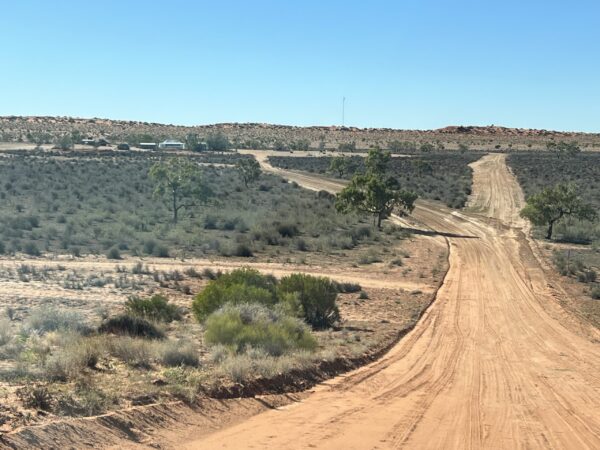 Approaching Old Andado Station bordered by large red dunes