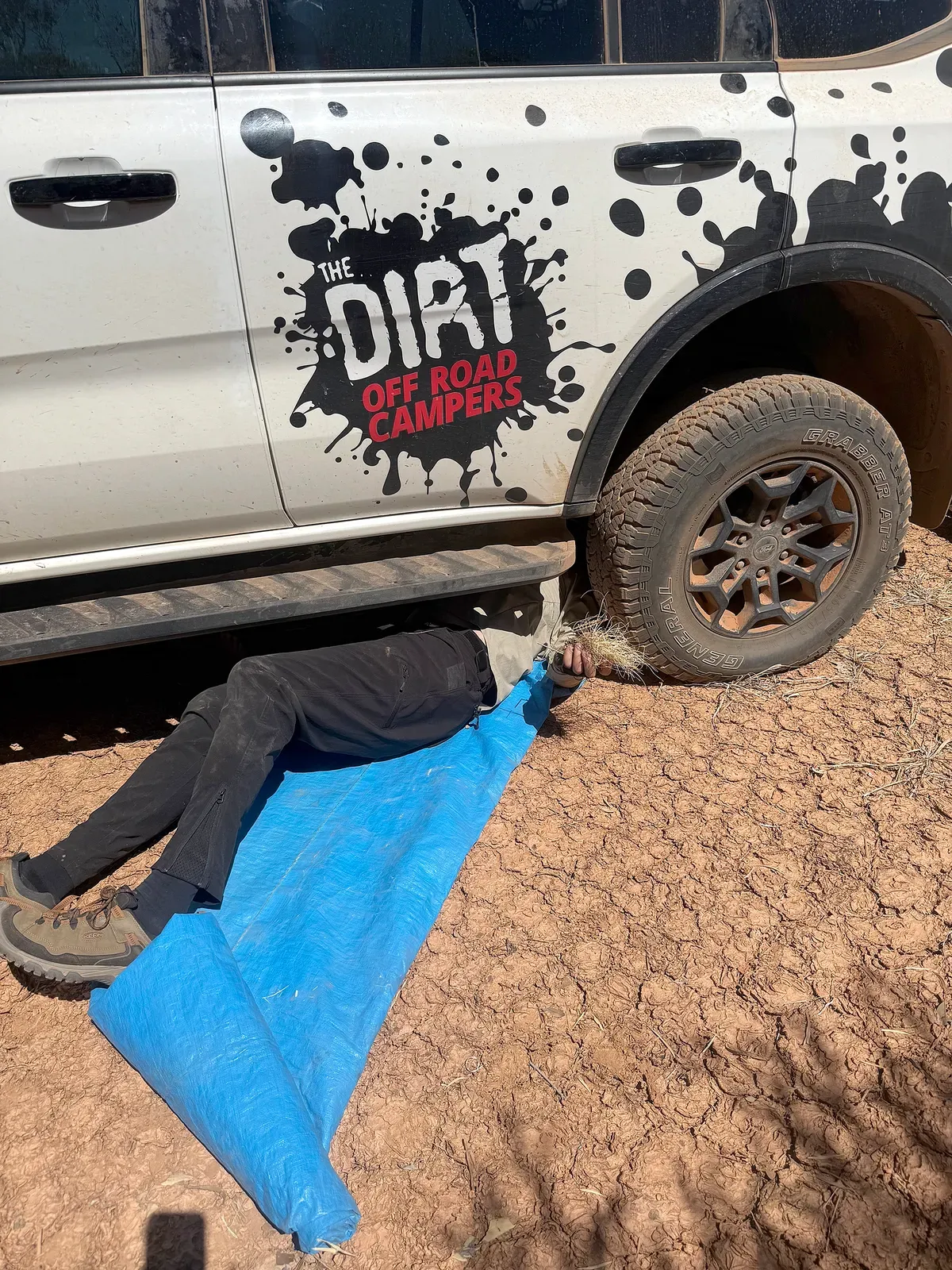 Mike underneath a Ford Everest Tremor checking the suspension and removing accumulated spinifex during the Canning Stock Route expedition.