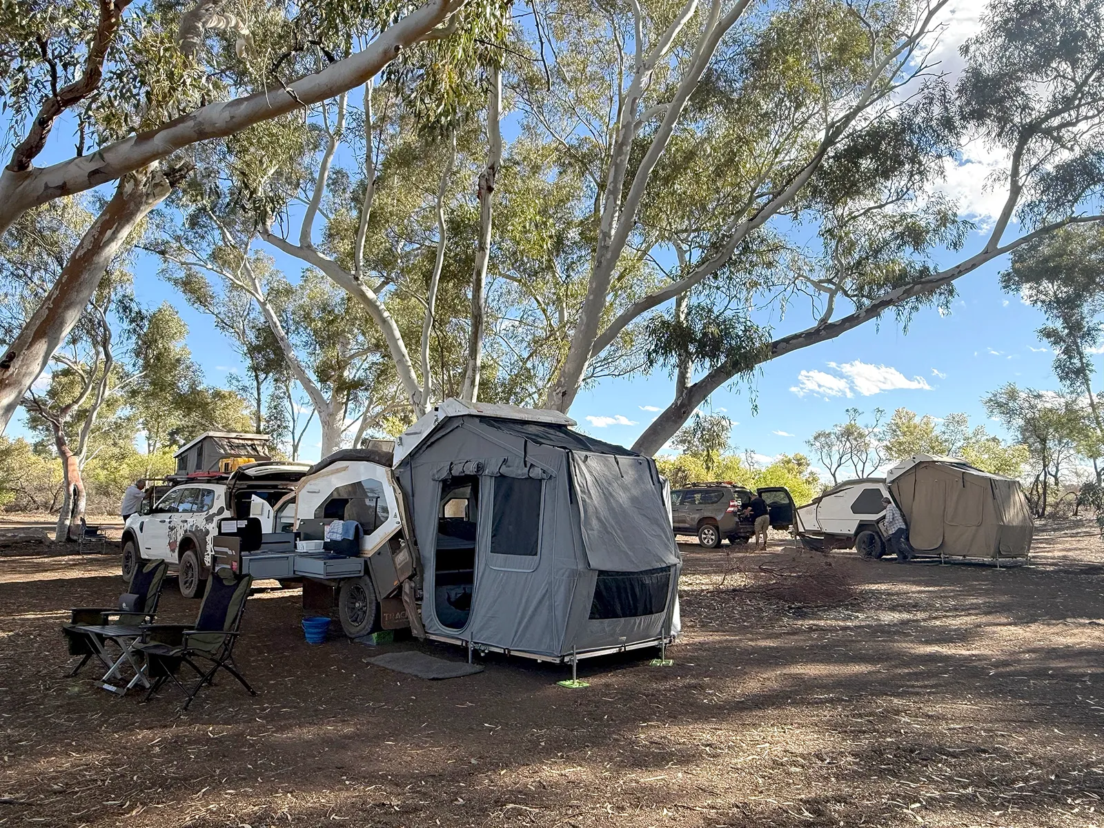 Two Tvans with their tent areas set up beneath gum trees at Pierre Springs, Well 6